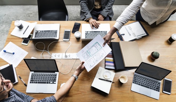 Image of people working on computers around a table